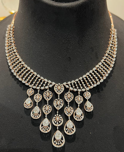 A gold diamond necklace with a geometric pattern and a pair of matching earrings, displayed on a mannequin bust.