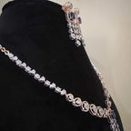 A gold diamond necklace with a matching set of earrings, featuring a series of round and marquise shaped diamonds set in a classic design on a mannequin bust.