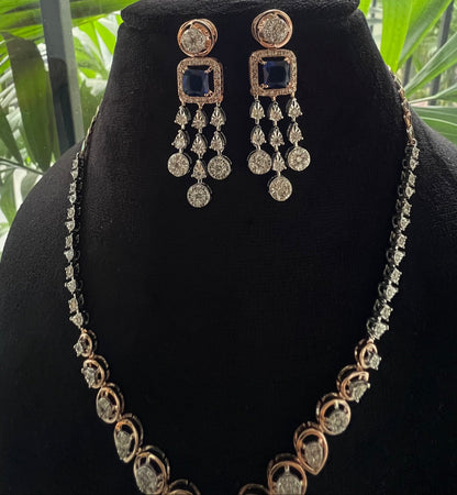 A gold diamond necklace with a matching set of earrings, featuring a series of round and marquise shaped diamonds set in a classic design on a mannequin bust.