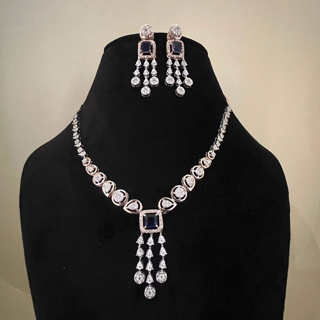 A gold diamond necklace with a matching set of earrings, featuring a series of round and marquise shaped diamonds set in a classic design on a mannequin bust.