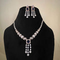 A gold diamond necklace with a matching set of earrings, featuring a series of round and marquise shaped diamonds set in a classic design on a mannequin bust.