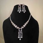 A gold diamond necklace with a matching set of earrings, featuring a series of round and marquise shaped diamonds set in a classic design on a mannequin bust.