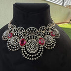 A gold diamond choker necklace with a floral pattern and red and white diamonds, displayed on a mannequin.