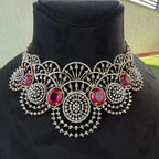 A gold diamond choker necklace with a floral pattern and red and white diamonds, displayed on a mannequin.