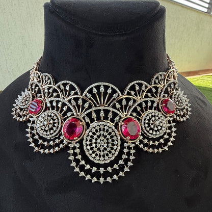 A gold diamond choker necklace with a floral pattern and red and white diamonds, displayed on a mannequin.