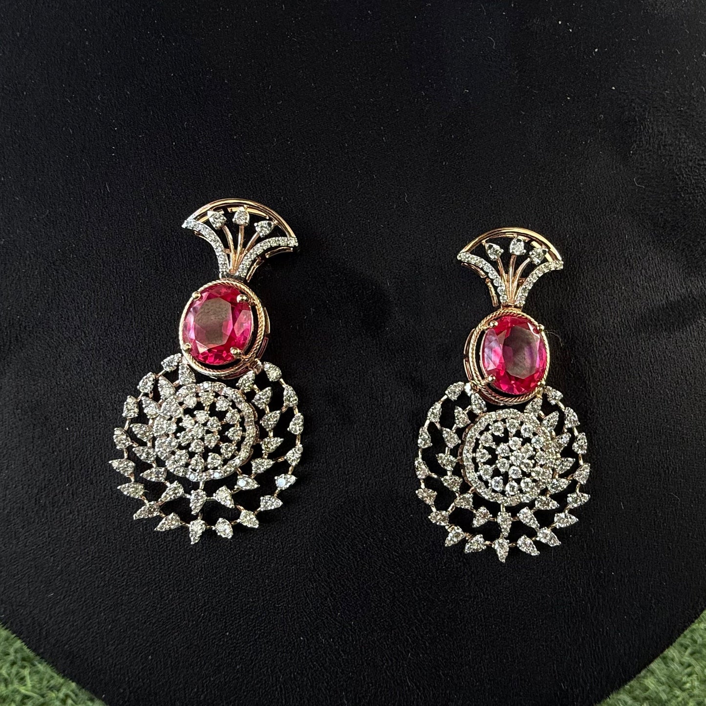 gold diamond earrings with a floral pattern and red and white diamonds, displayed on a mannequin.