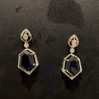 A gold diamond necklace with a geometric pendant and matching earrings displayed on a mannequin bust.