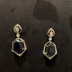 A gold diamond necklace with geometric matching earrings displayed on a mannequin bust.