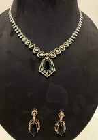 A gold diamond necklace with a geometric pendant and matching earrings displayed on a mannequin bust.