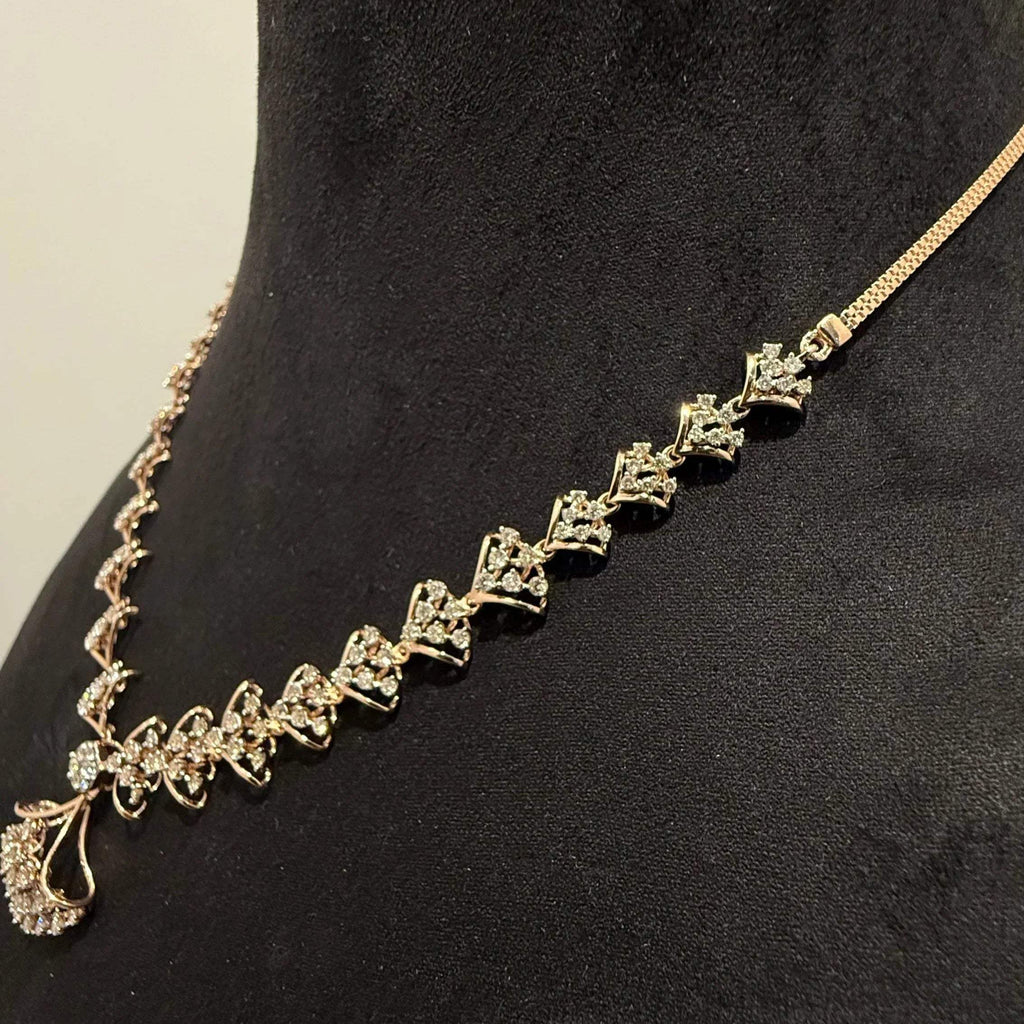 A luxurious gold diamond necklace with earrings set, displayed on a mannequin bust.