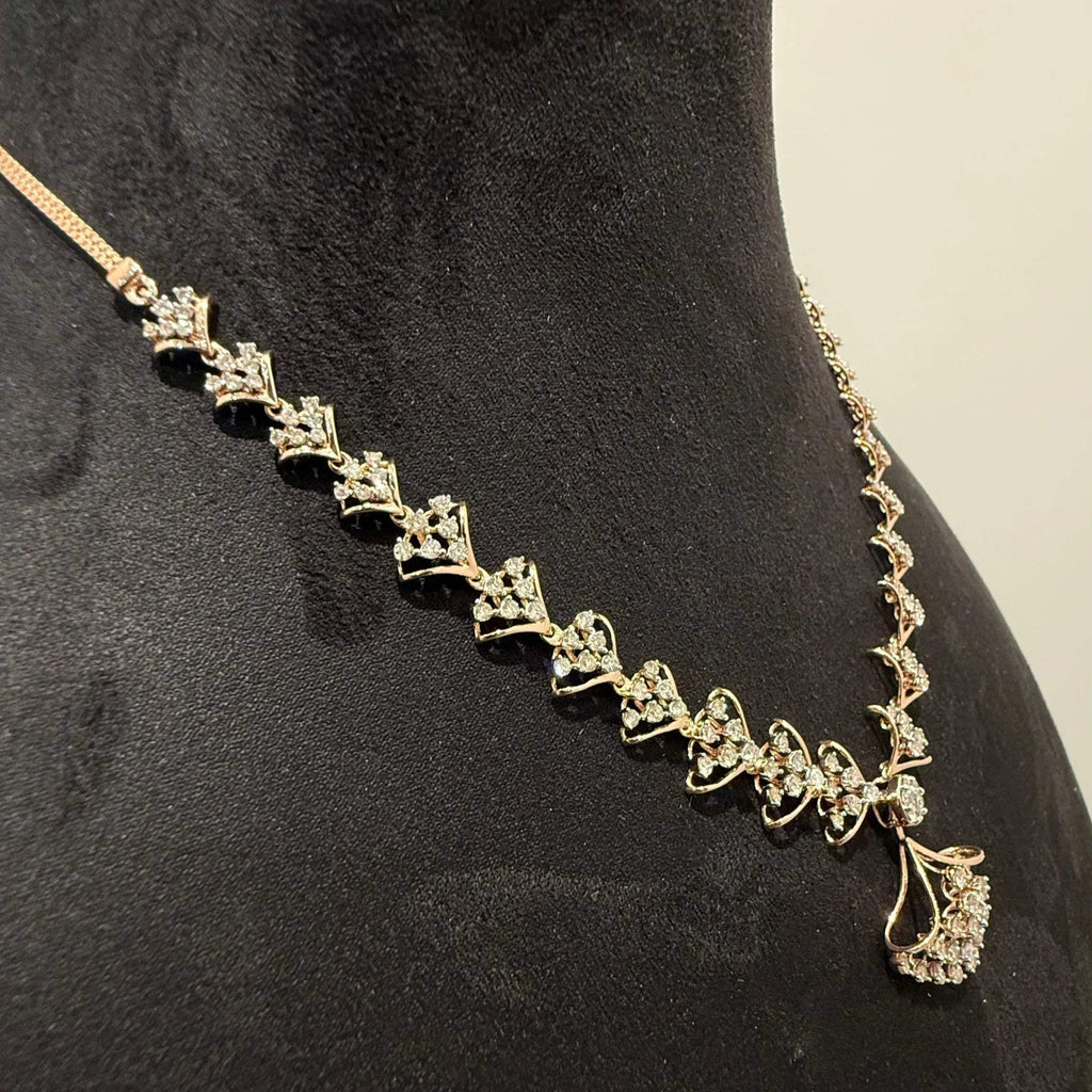A luxurious gold diamond necklace with earrings set, displayed on a mannequin bust.