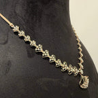A luxurious gold diamond necklace with earrings set, displayed on a mannequin bust.