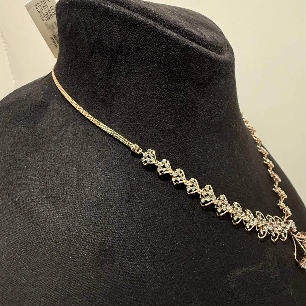 A luxurious gold diamond necklace with earrings set, displayed on a mannequin bust.