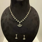 A luxurious gold diamond necklace with earrings set, displayed on a mannequin bust.