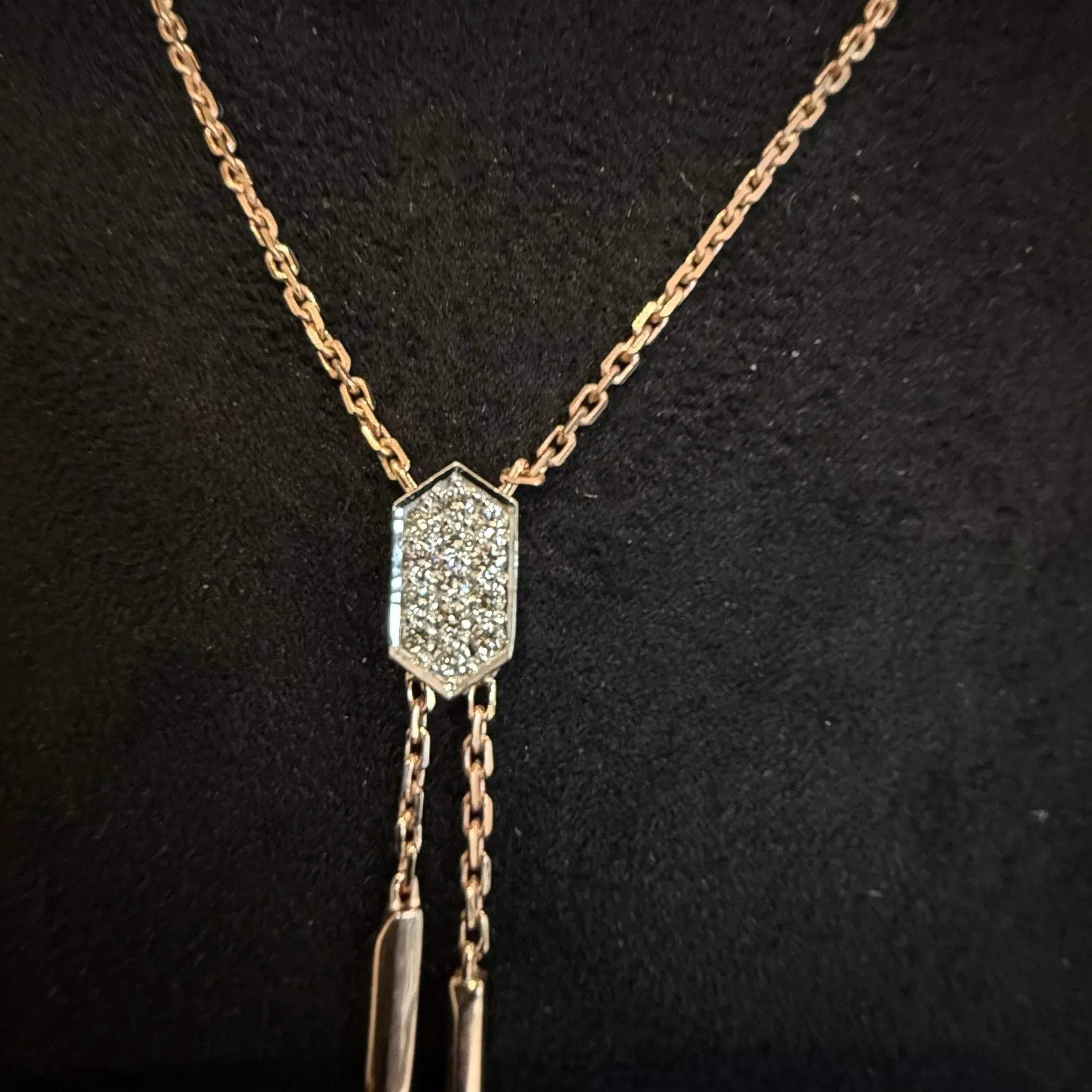 Modern diamond necklace set with hexagon pendant on display.