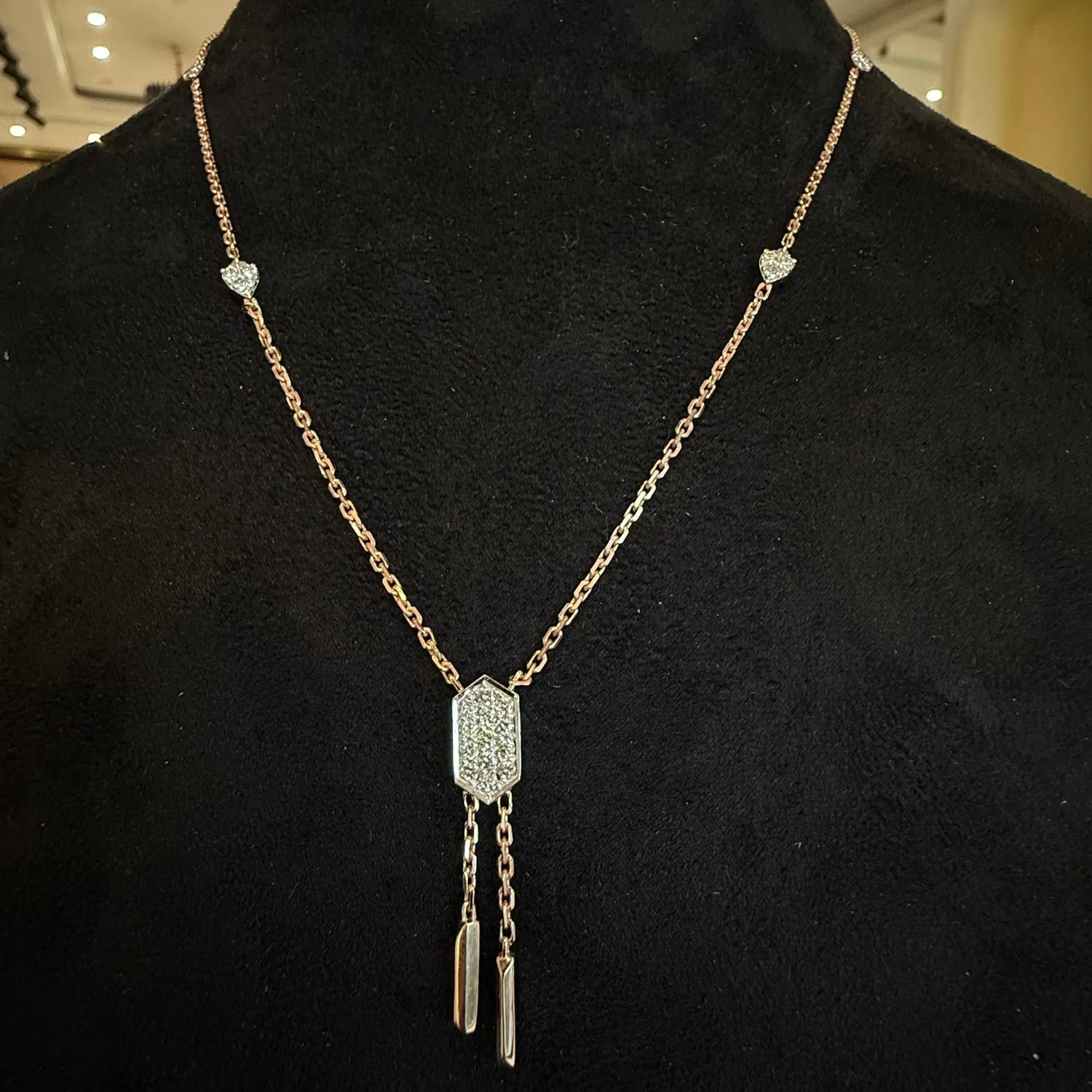 A gold diamond necklace with a chain design and a single large diamond pendant, accompanied by a matching pair of earrings with smaller diamonds.