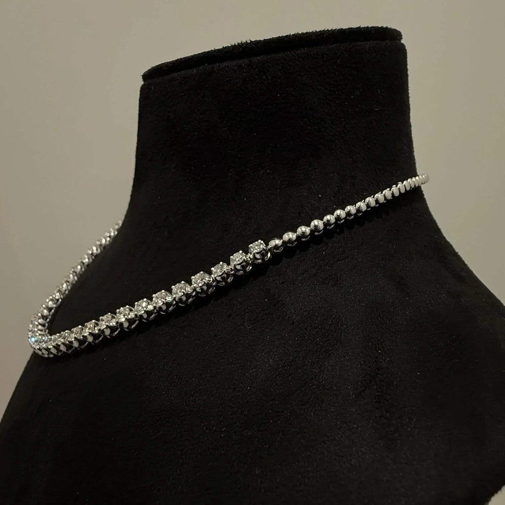 Elegant round cut diamond necklace set displayed on a black mannequin stand.