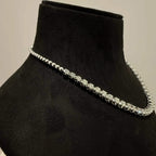 Elegant round cut diamond necklace set displayed on a black mannequin stand.
