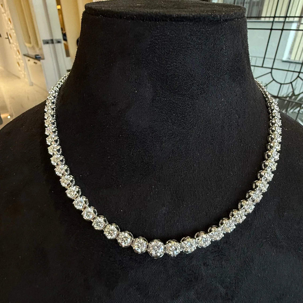 Elegant round cut diamond necklace set displayed on a black mannequin stand.