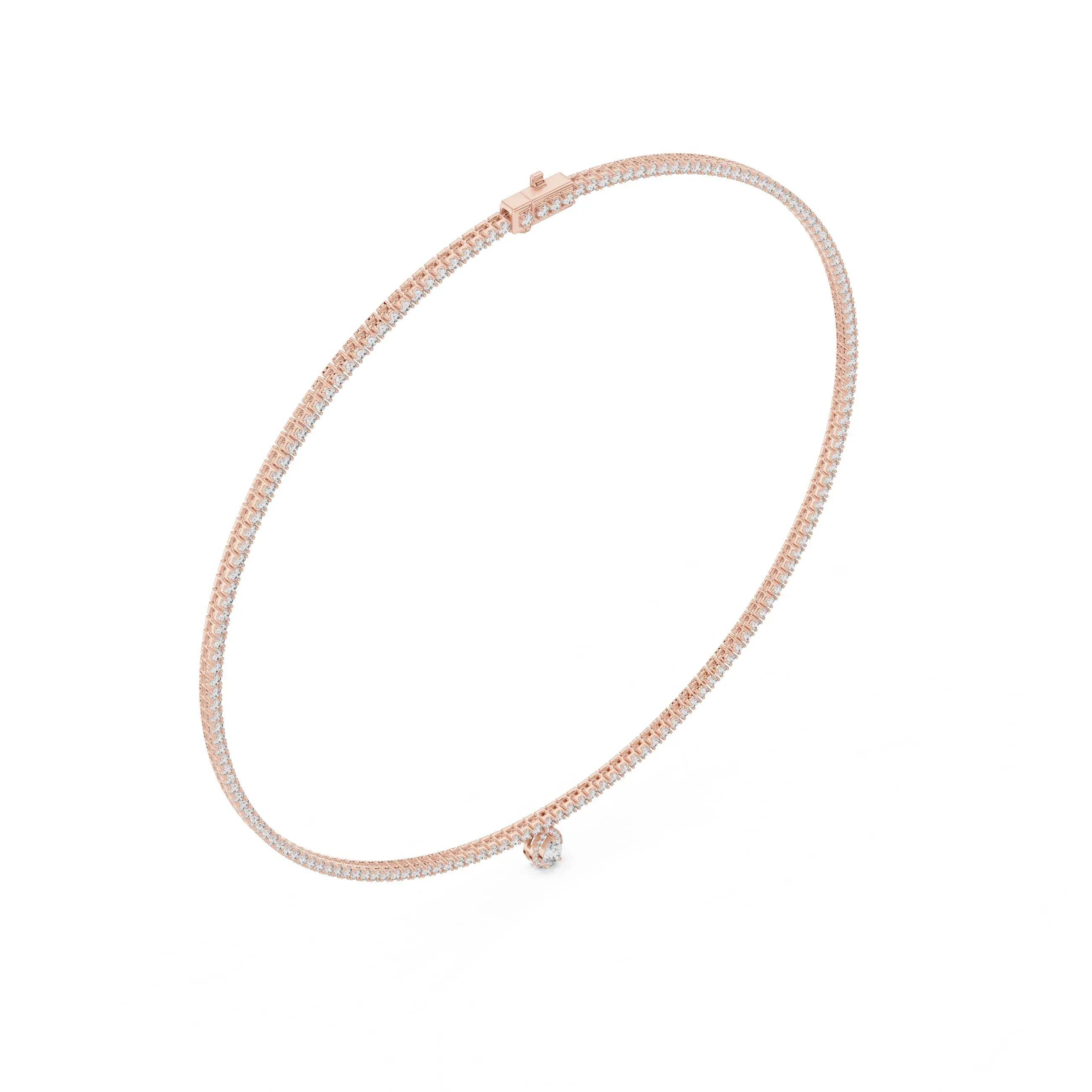 Gold and diamond tennis necklace with a small pear shape diamond pendant on a white background
