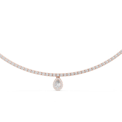 Gold and diamond tennis necklace with a small pear shape diamond pendant on a white background.