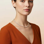 Woman wearing a real diamonds tennis necklace with a plain background