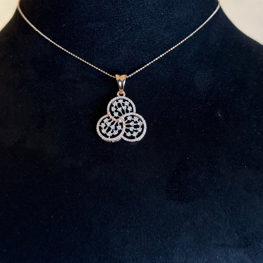 A gold diamond pendant with a floral design, displayed on a black mannequin necklace stand.