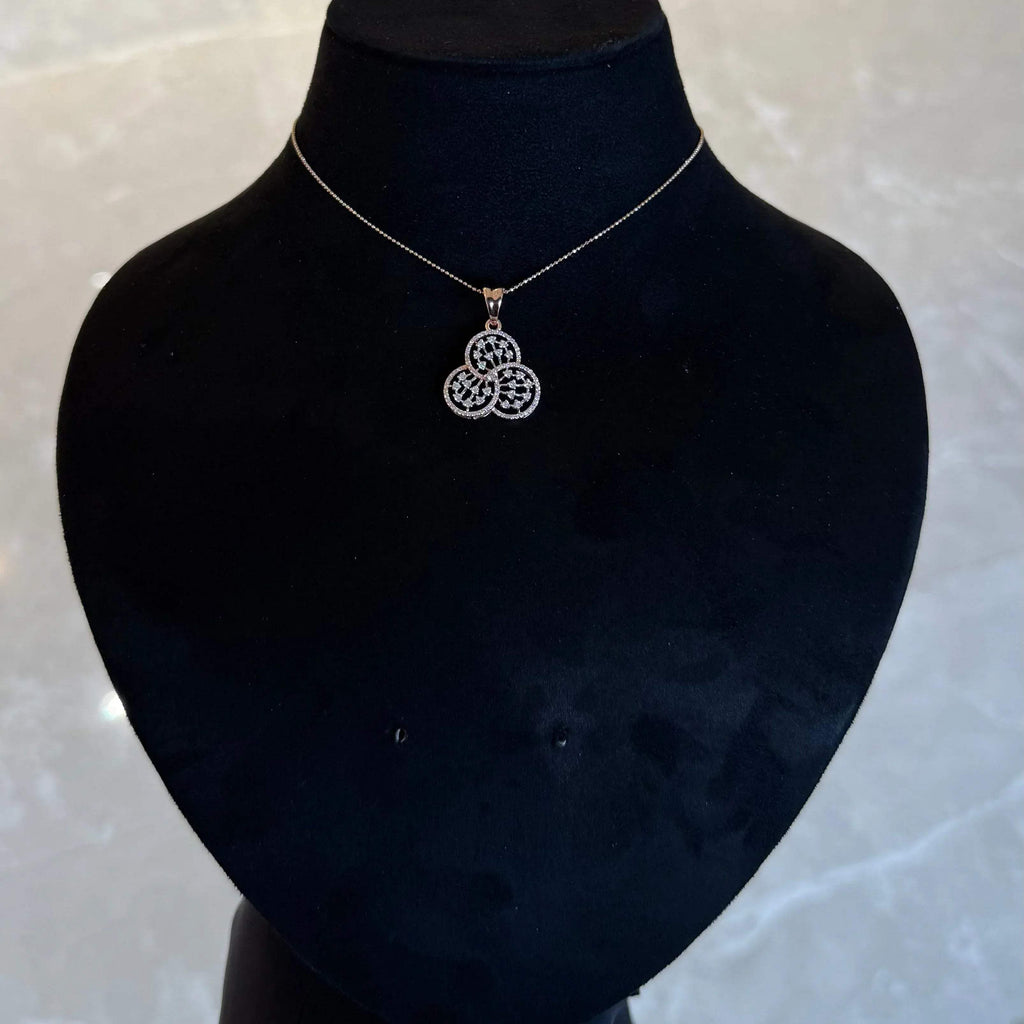 A gold diamond pendant with a floral design, displayed on a black mannequin necklace stand.
