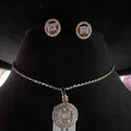 A mannequin showcasing a gold diamond pendant and earrings set, with the pendant hanging from a chain and the earrings displayed above.
