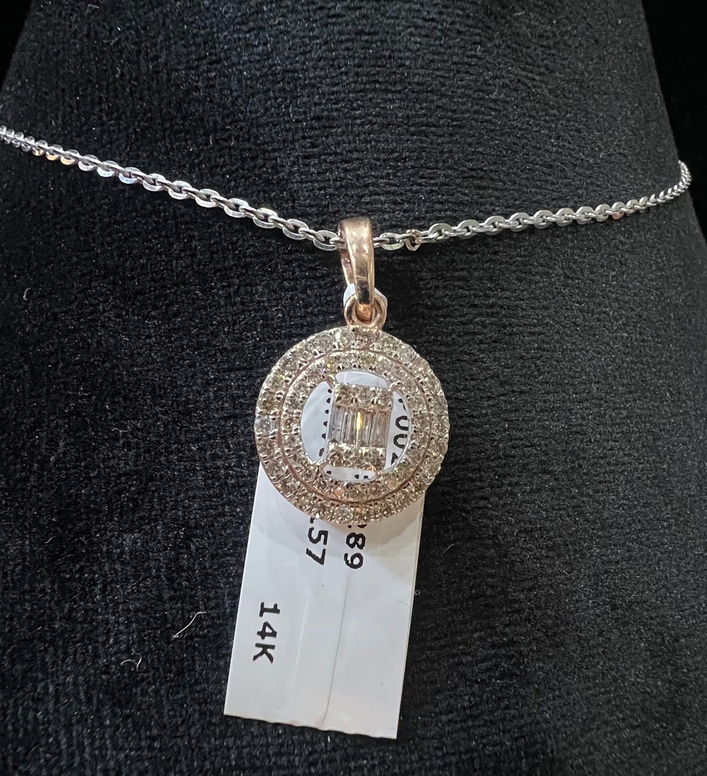 A mannequin showcasing a gold diamond pendant hanging from a chain displayed.