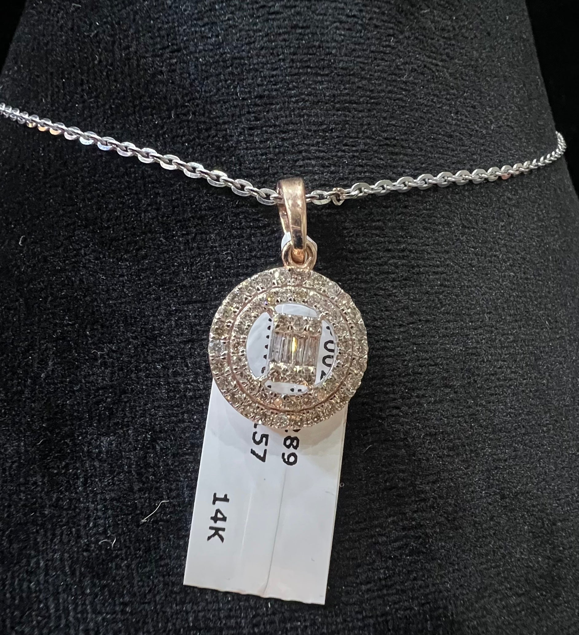 A mannequin showcasing a gold diamond pendant hanging from a chain displayed.