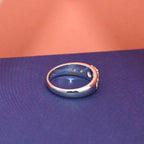 White gold ring with real diamonds on a blue surface