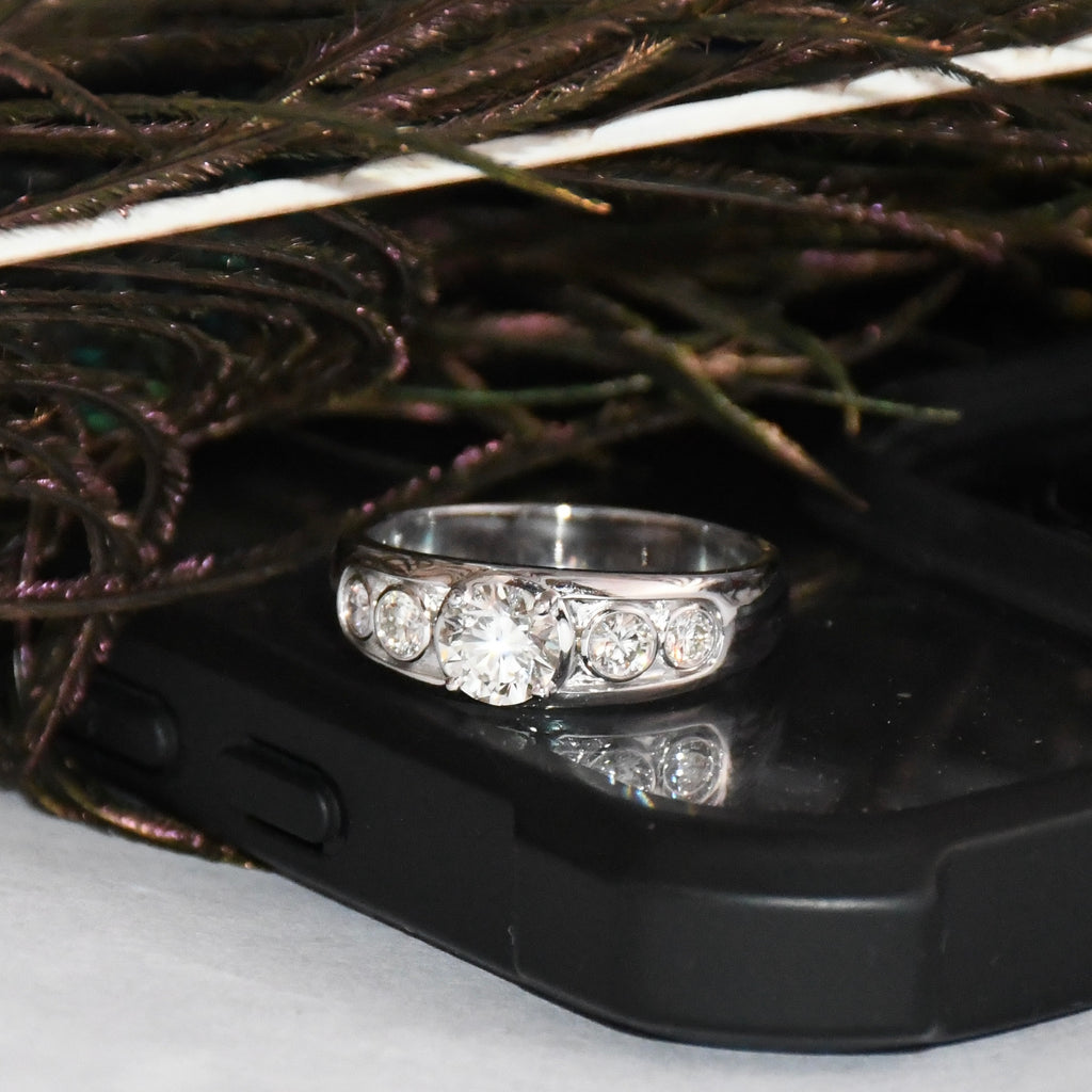 White gold ring with real diamonds on a black phone case with decorative background