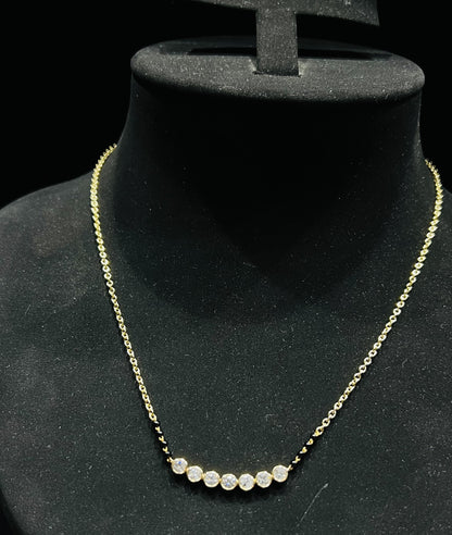 A stylish gold diamond beaded mangalsutra with seven round bezel-set diamonds in a row, paired with small black beads on a delicate gold chain.