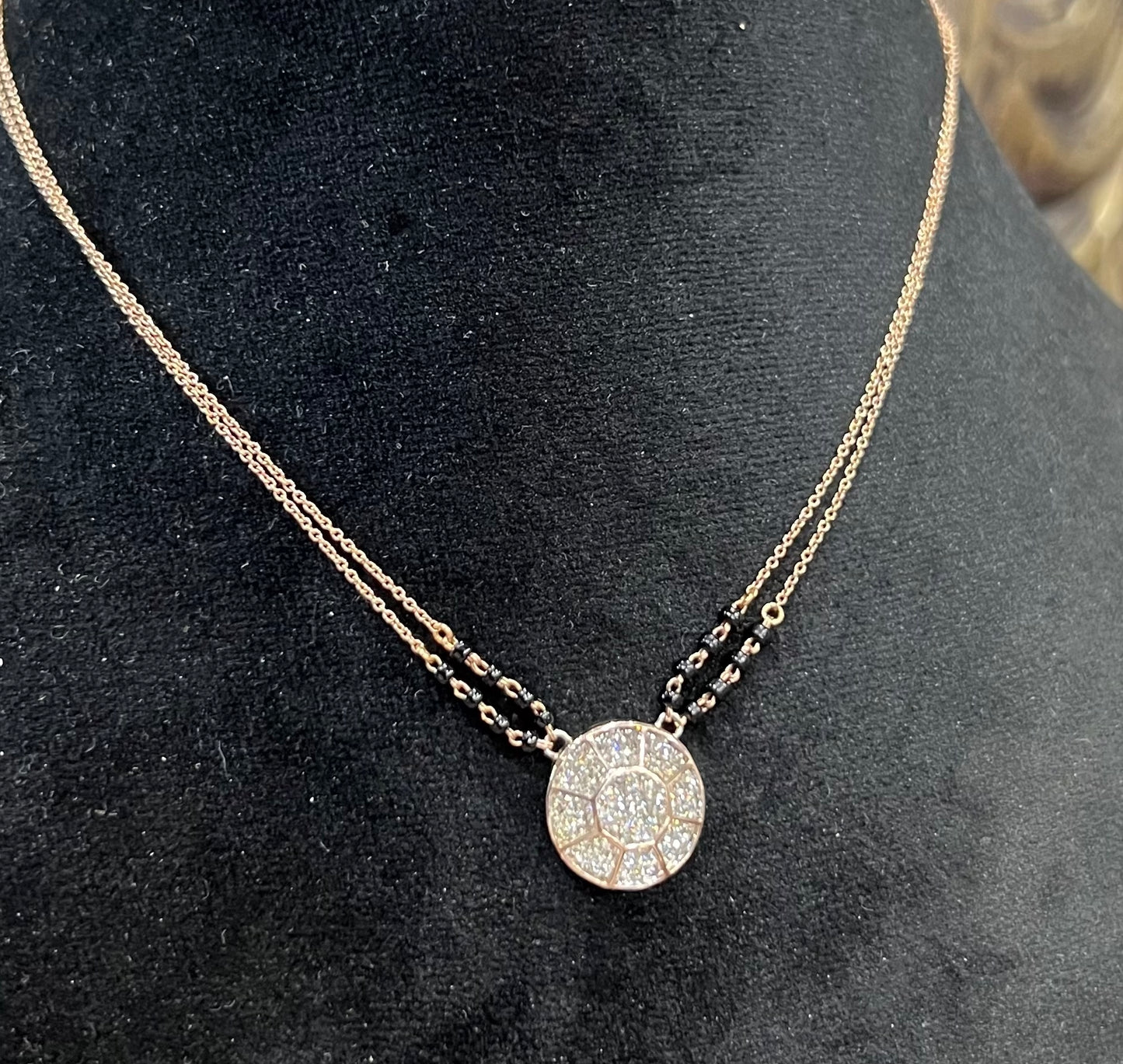 Elegant gold diamond mangalsutra with a circular diamond-studded pendant in honeycomb design, paired with black bead and gold chain for a modern traditional look.