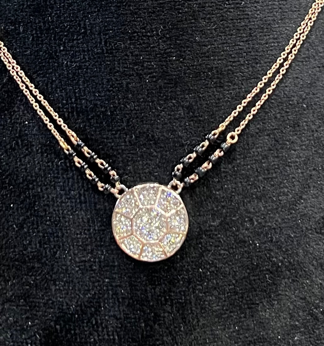Elegant gold diamond mangalsutra with a circular diamond-studded pendant in honeycomb design, paired with black bead and gold chain for a modern traditional look.