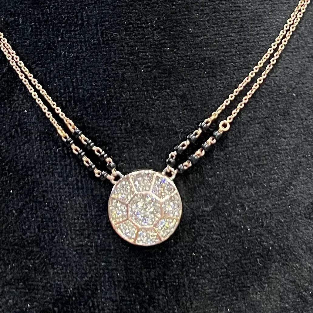 Elegant gold diamond mangalsutra with a circular diamond-studded pendant in honeycomb design, paired with black bead and gold chain for a modern traditional look.