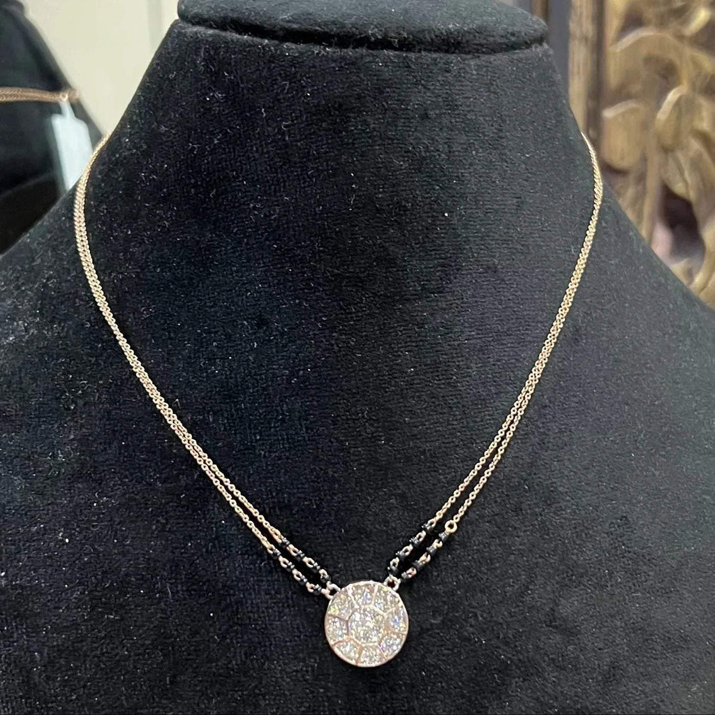 Elegant gold diamond mangalsutra with a circular diamond-studded pendant in honeycomb design, paired with black bead and gold chain for a modern traditional look.