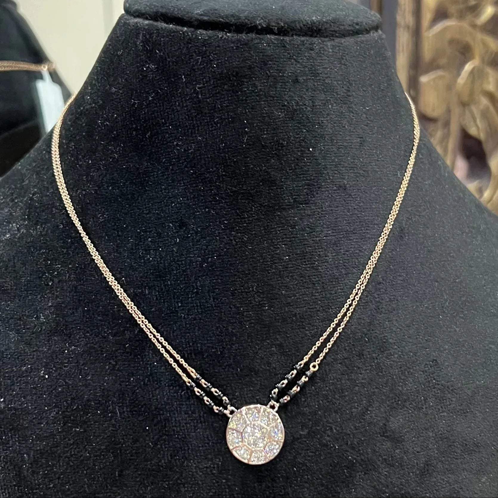 Elegant gold diamond mangalsutra with a circular diamond-studded pendant in honeycomb design, paired with black bead and gold chain for a modern traditional look.