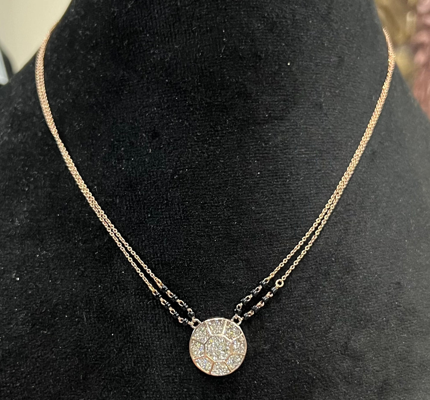 Elegant gold diamond mangalsutra with a circular diamond-studded pendant in honeycomb design, paired with black bead and gold chain for a modern traditional look.