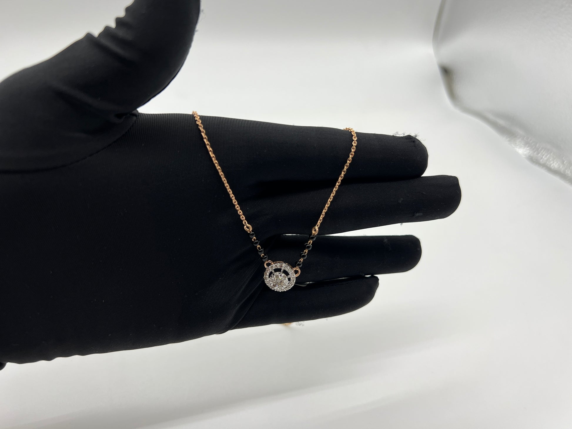 Elegant gold diamond mangalsutra with round halo diamond pendant and dual black bead gold chain, perfect for daily wear and modern bridal style.