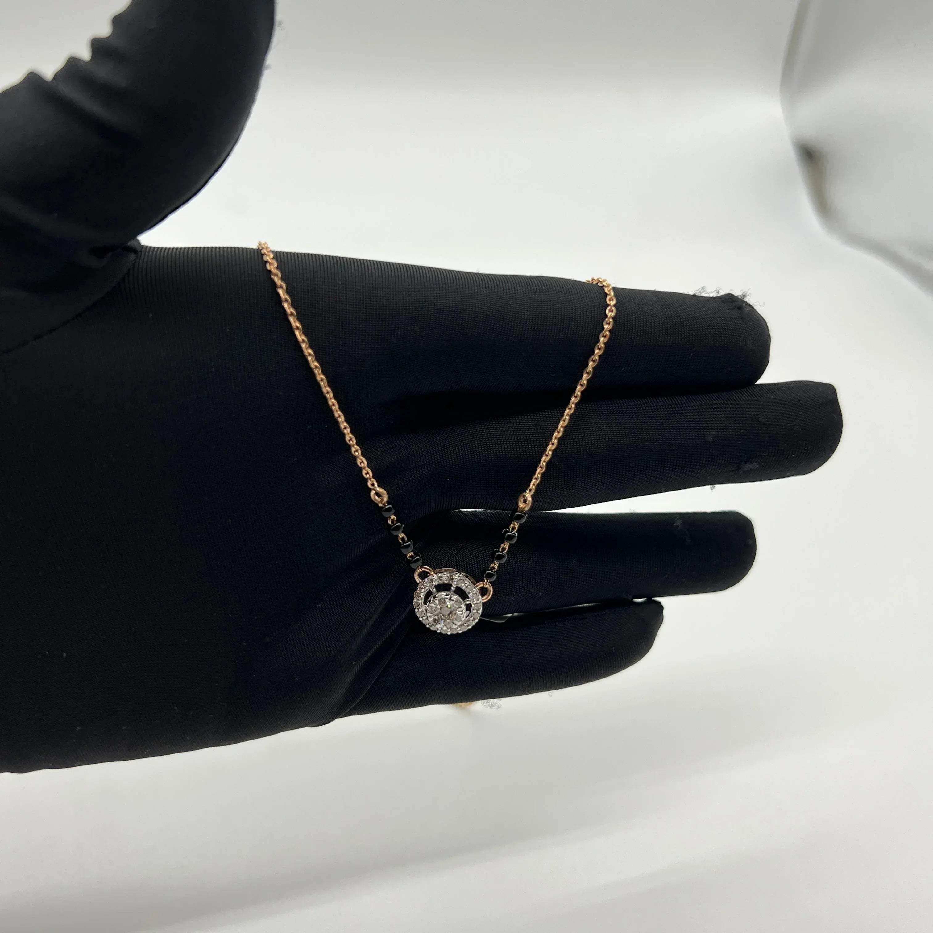 Elegant gold diamond mangalsutra with round halo diamond pendant and dual black bead gold chain, perfect for daily wear and modern bridal style.