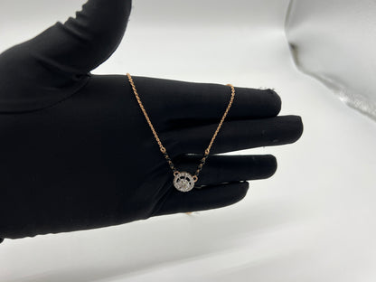 Elegant gold diamond mangalsutra with round halo diamond pendant and dual black bead gold chain, perfect for daily wear and modern bridal style.