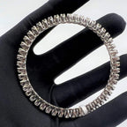 White gold ring with lab grown diamond on a black glove.
