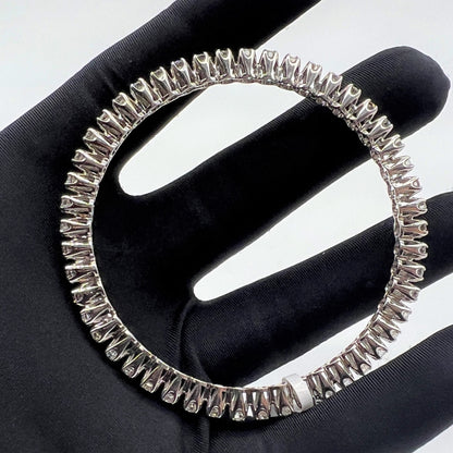 White gold ring with lab grown diamond on a black glove.