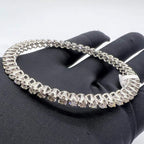 White gold bangles with lab grown diamonds on a black glove with a white background.