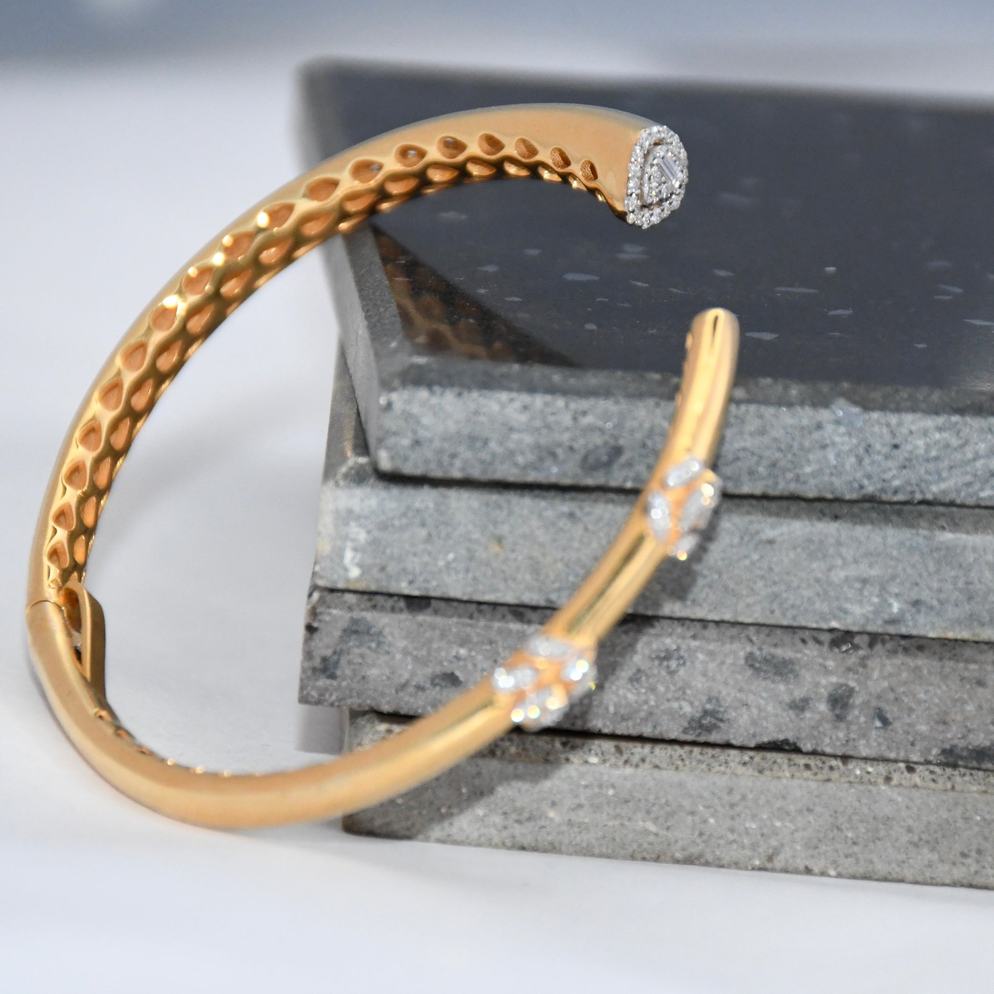 Gold bracelet with lab grown diamond accents on a textured surface