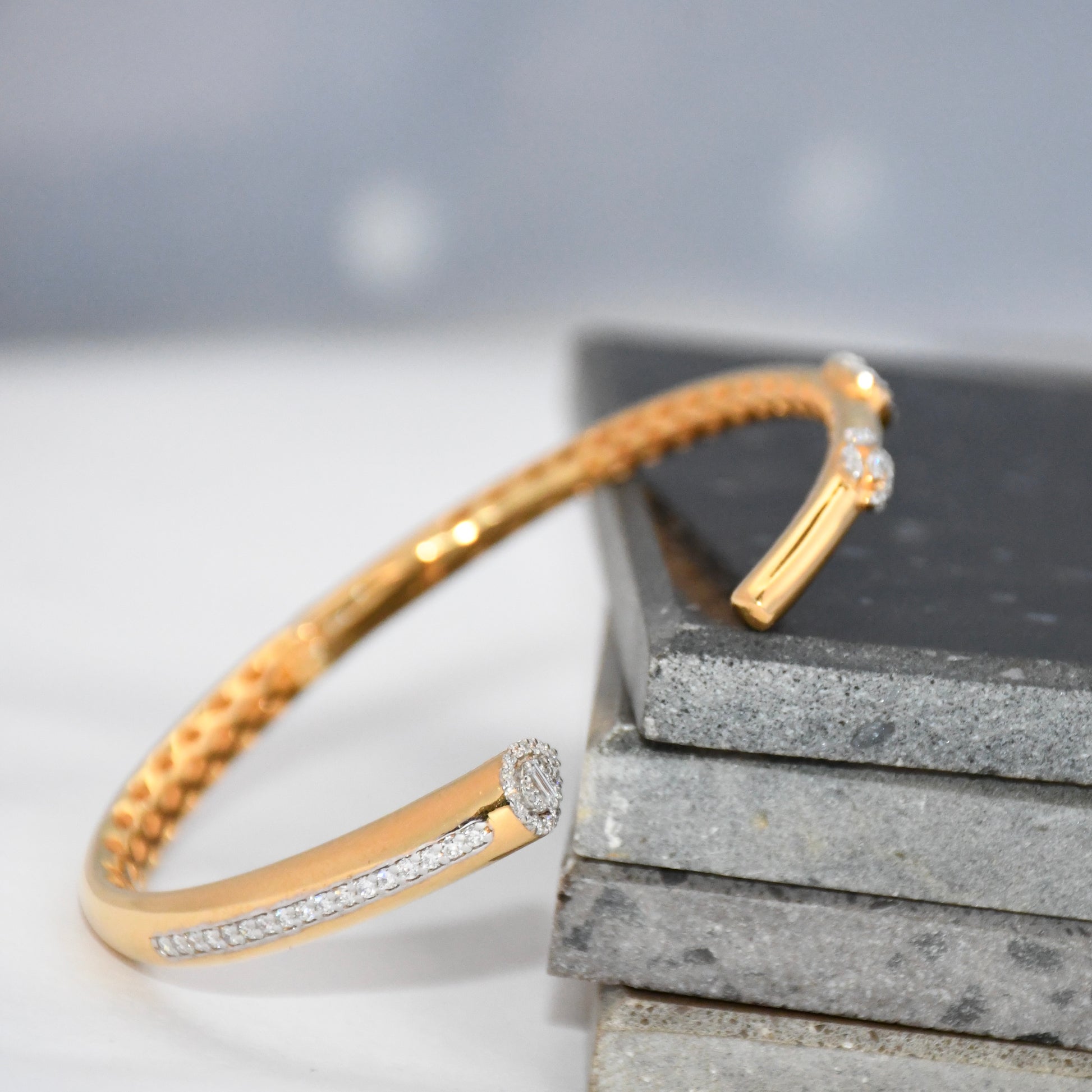 Gold bracelet with lab grown  diamond accents on a gray surface