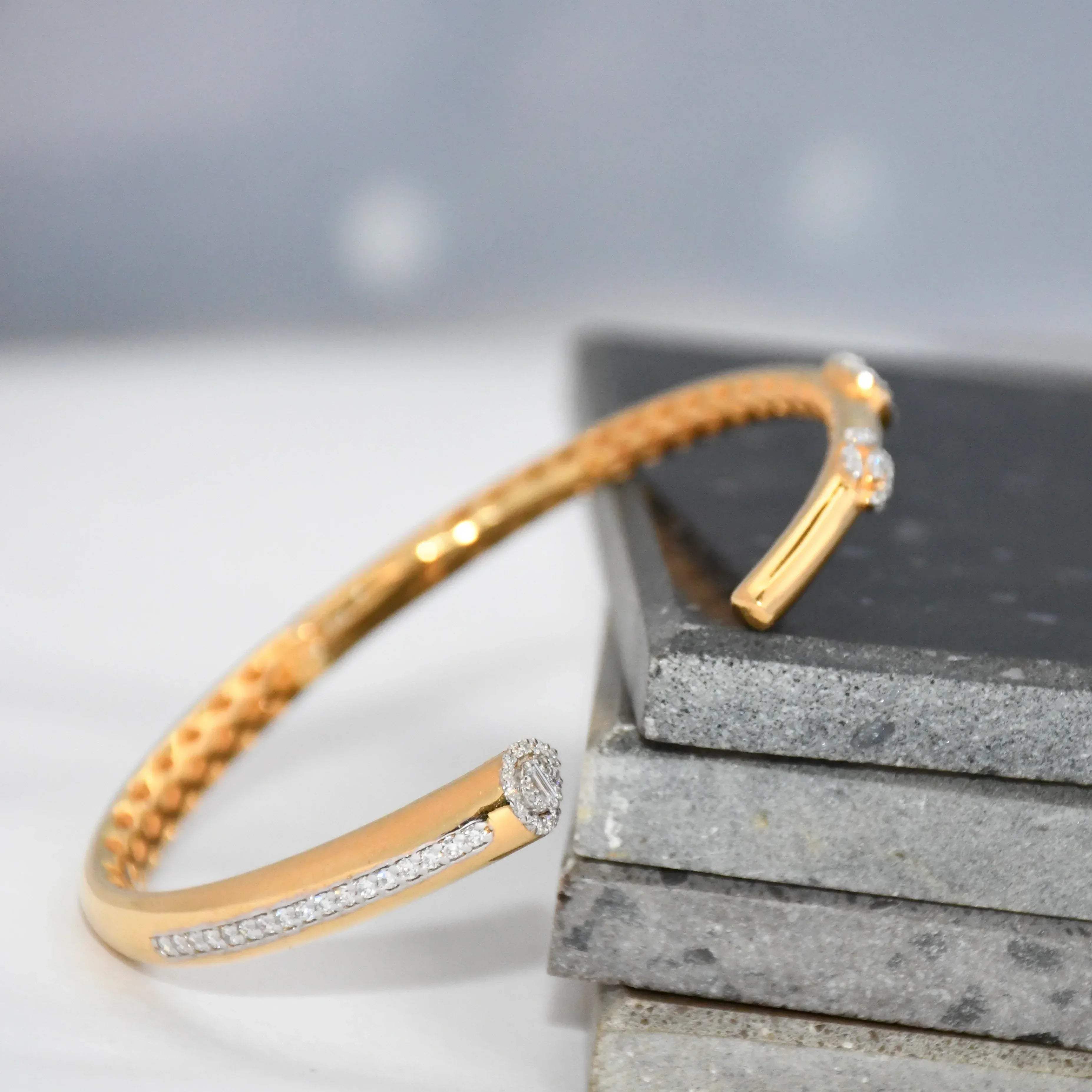Gold bracelet with lab grown  diamond accents on a gray surface