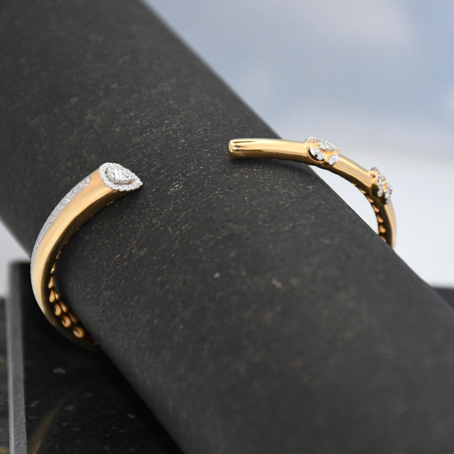 Gold bracelet with lab grown diamond accents on a black surface